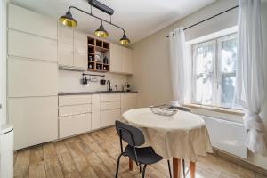 a kitchen with a table and chairs and a sink at L'Expresso in Frontonas