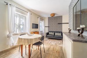 a kitchen and living room with a table and a couch at L'Expresso in Frontonas