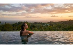 a woman standing in a pool in the water at Auralta Rio Celeste I Elohi Collection in Rio Celeste