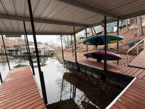 a dock with two umbrellas on a body of water at A Frame Escape Lake Access in Rocky Mount