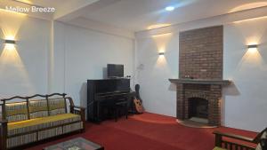 a living room with a fireplace and a piano at Mellow Breeze - Nuwara Eliya in Nuwara Eliya