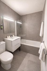 a bathroom with a toilet and a sink and a tub at Logis Hôtel Restaurant Les Fontaines in Lanvollon