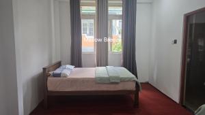 a small bed in a room with a window at Mellow Breeze - Nuwara Eliya in Nuwara Eliya