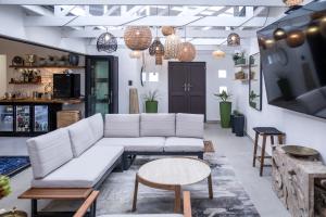 a living room with a white couch and tables at Lagoon Haven House in Hermanus