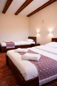 a room with three beds with towels on them at Stara Kuźnia Mazurska in Węgorzewo +31 photos