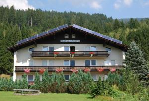 ein großes Gebäude mit Blumen auf den Balkonen in der Unterkunft Hotel Sonnleitn in Jenig