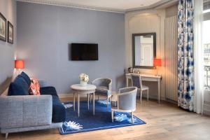 a living room with a couch and a table and chairs at Hôtel Château Frontenac in Paris