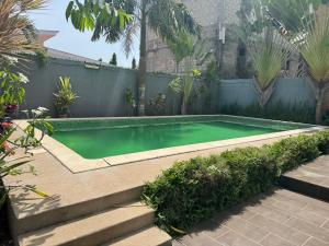 a small swimming pool in a backyard with plants at CNS Guest House in Grand-Bassam