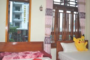 a bedroom with two beds and a pikachu toy on the pillow at Phong Nha Homestay in Phong Nha