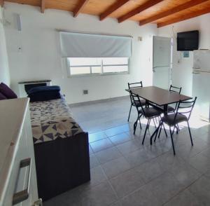 a room with a table and chairs and a bed at Gotas de Rocío - para 4 en San Antonio Oeste in San Antonio Oeste