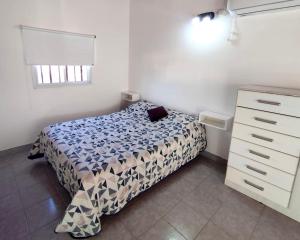a small bedroom with a bed and a dresser at Gotas de Rocío - para 4 en San Antonio Oeste in San Antonio Oeste