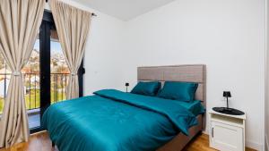 a bedroom with a bed with blue sheets and a window at Royal View Cetinje in Cetinje +39 photos