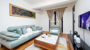 a living room with a blue couch and a table at Royal View Cetinje in Cetinje