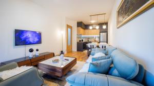 a living room with a blue couch and a table at Royal View Cetinje in Cetinje