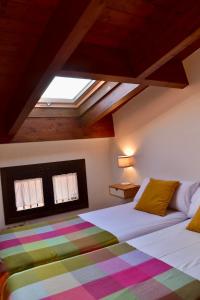 a bedroom with a bed with a colorful blanket at Casa albañil, aptos en la Ribagorza, arte, ciclismo, naturaleza y enoturismo, entre Graus y Torreciudad in La Puebla de Castro +105 photos