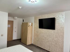 a bedroom with a flat screen tv on a wall at Academia De Arhitectura in Piteşti