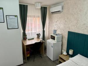 a small room with a desk and a microwave at Academia De Arhitectura in Piteşti