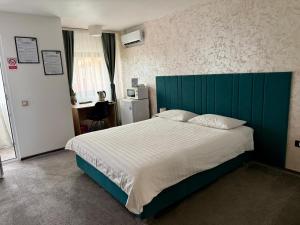 a bedroom with a large bed with a blue headboard at Academia De Arhitectura in Piteşti