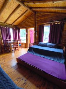 a bedroom with a large bed with purple sheets at Complejo majua in Cosquín +63 photos