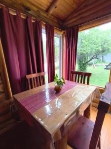 a wooden table in a room with a large window at Complejo majua in Cosquín