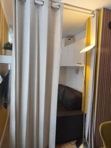 a shower curtain in a room with a couch at Le 4 Saisons in Ustou