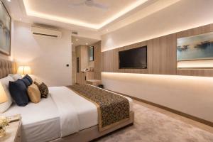 a hotel room with a bed and a flat screen tv at OPO Premier Ro'yal Delhi Airport - FREE Airport Pickup Or Drop in New Delhi