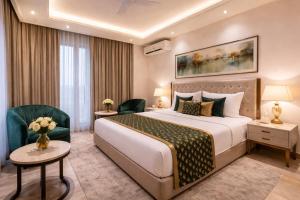 a hotel room with a large bed and chairs at OPO Premier Ro'yal Delhi Airport - FREE Airport Pickup Or Drop in New Delhi