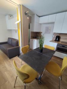 a living room with a table and yellow chairs at Le 4 Saisons in Ustou