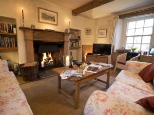 a living room with a table and a fireplace at 4 Bed in Kettlewell oc-g0041 in Starbotton