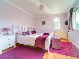 a bedroom with a white bed and a purple rug at 2 Bed in Brighstone oc-ic132 in Brighstone