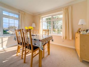 a dining room with a table and chairs and windows at 2 Bed in Brighstone oc-ic132 in Brighstone