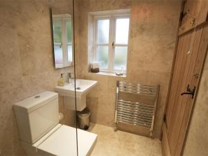 a bathroom with a toilet and a sink and a window at 4 Bed in Kettlewell oc-g0041 in Starbotton +23 photos