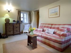a living room with a couch and a table with flowers at 4 Bed in Kettlewell oc-g0041 in Starbotton