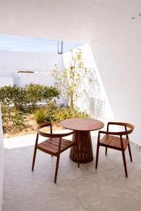 a wooden table and two chairs and a table at MykoNest in Agios Stefanos