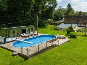 a swimming pool in a yard next to a house at 6 Bed in Lymington oc-56765 in Boldre