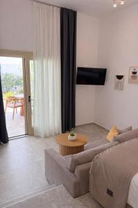 a living room with a couch and a table at MykoNest in Agios Stefanos