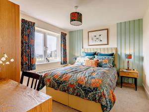 a bedroom with a bed and a table and a window at 1 Bed in Sherborne oc-87292 in Lillington