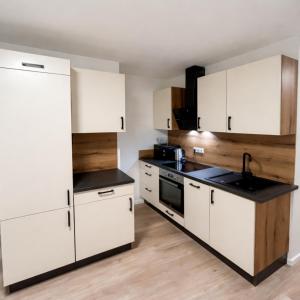 a kitchen with white cabinets and a sink at Family Apartment near Mölltaler Gletscher 2 in Flattach