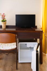 a desk with a tv and a computer on it at b&b casa pistacchio in Lovere