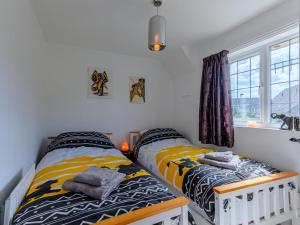 two twin beds in a room with a window at 3 Bed in Wareham oc-78831 in Corfe Castle