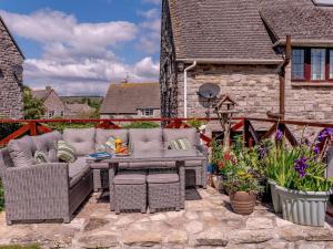 a patio with a table and chairs and flowers at 3 Bed in Wareham oc-78831 in Corfe Castle