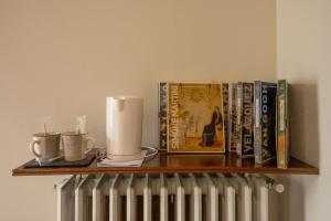 a shelf with books and cups and a radiator at b&b casa pistacchio in Lovere