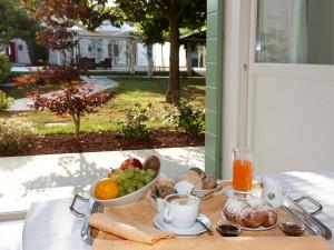 a breakfast table with a bowl of fruit and a glass of orange juice at Hotel Villa Patriarca - Buongiorno! Hotels in Mirano +28 photos