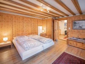 a bedroom with a bed in a room with wooden walls at Apartment Chesa Treig by Interhome in Samedan