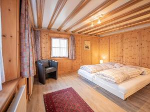 a bedroom with a bed and a chair in it at Apartment Chesa Treig by Interhome in Samedan