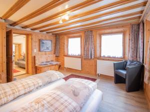 a room with two beds and a chair in it at Apartment Chesa Treig by Interhome in Samedan