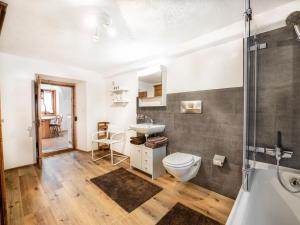 a bathroom with a toilet and a sink and a shower at Apartment Chesa Treig by Interhome in Samedan