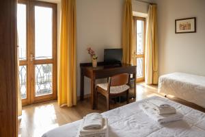 a bedroom with two beds and a desk with a computer at b&b casa pistacchio in Lovere