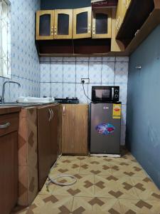 a kitchen with a refrigerator and a microwave at CJ apartment kasoa in Kasoa +6 photos