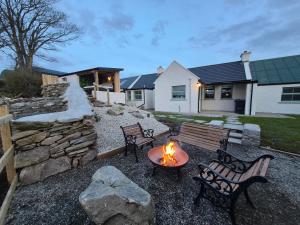 a backyard with two benches and a fire pit at Annies Farm Cottage in Derry Londonderry